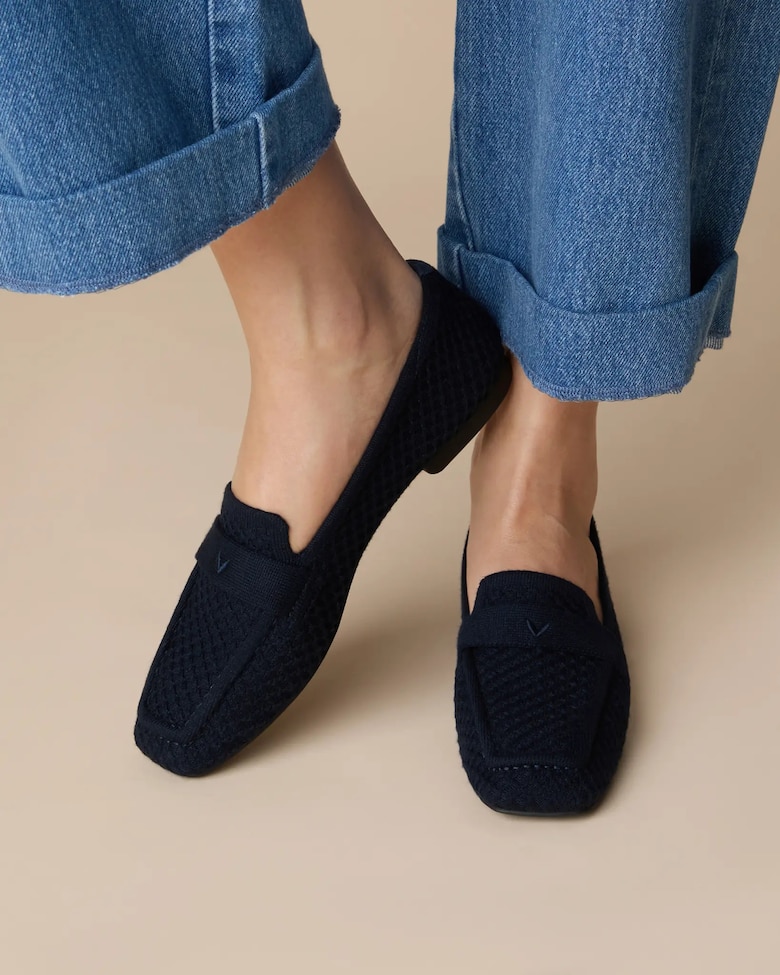 Navy VIVAIA loafers worn with bare ankles