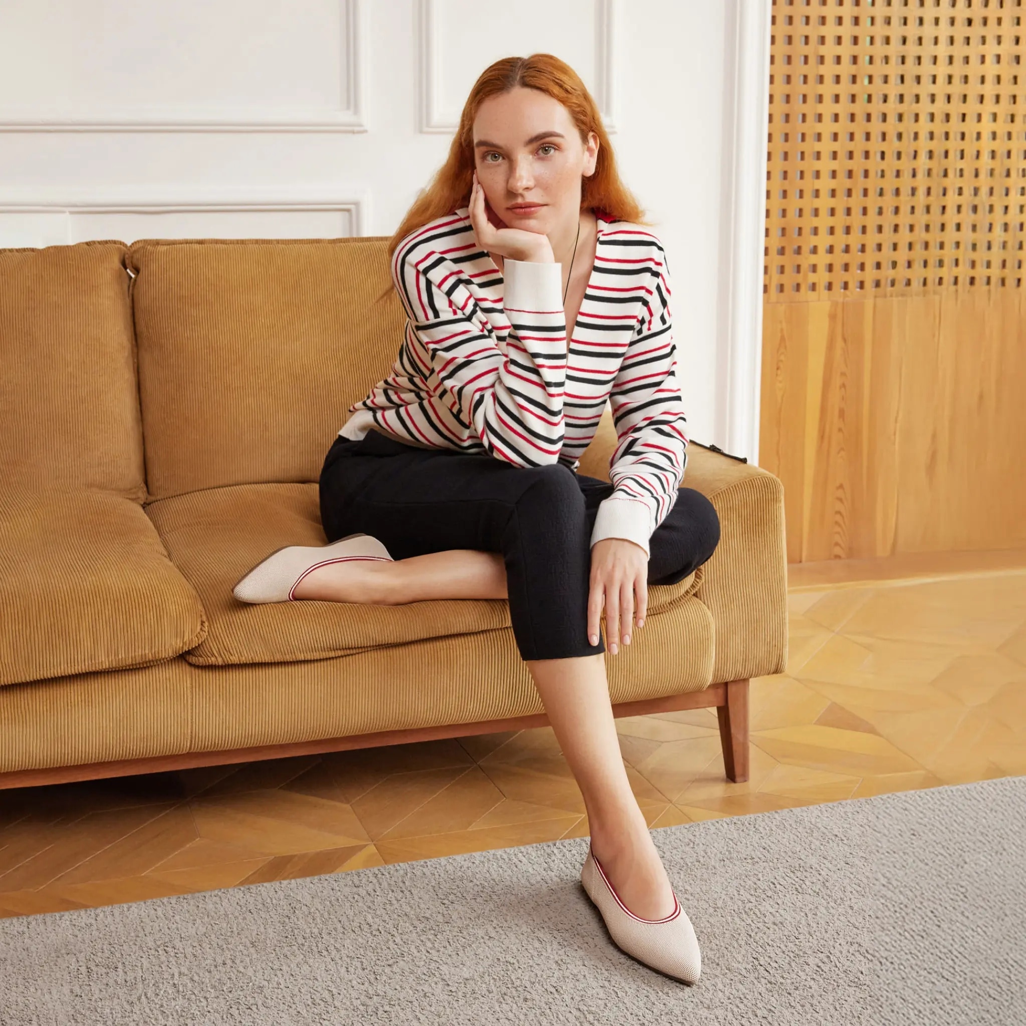 Woman relaxing on sofa wearing Aria 5° flats — lifestyle shot