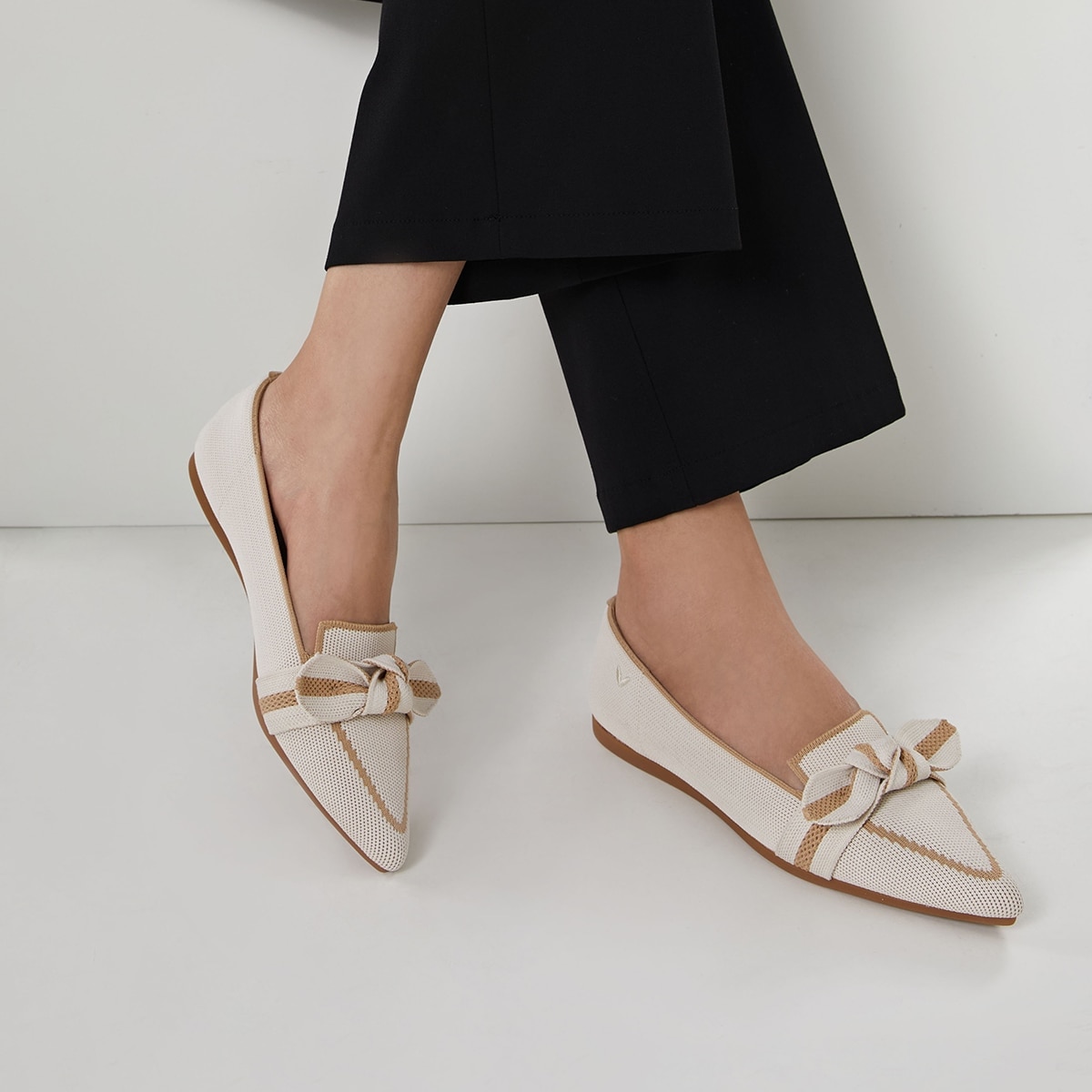 Model wearing VIVAIA Michelle 2.0 ivory bow loafers with black trousers