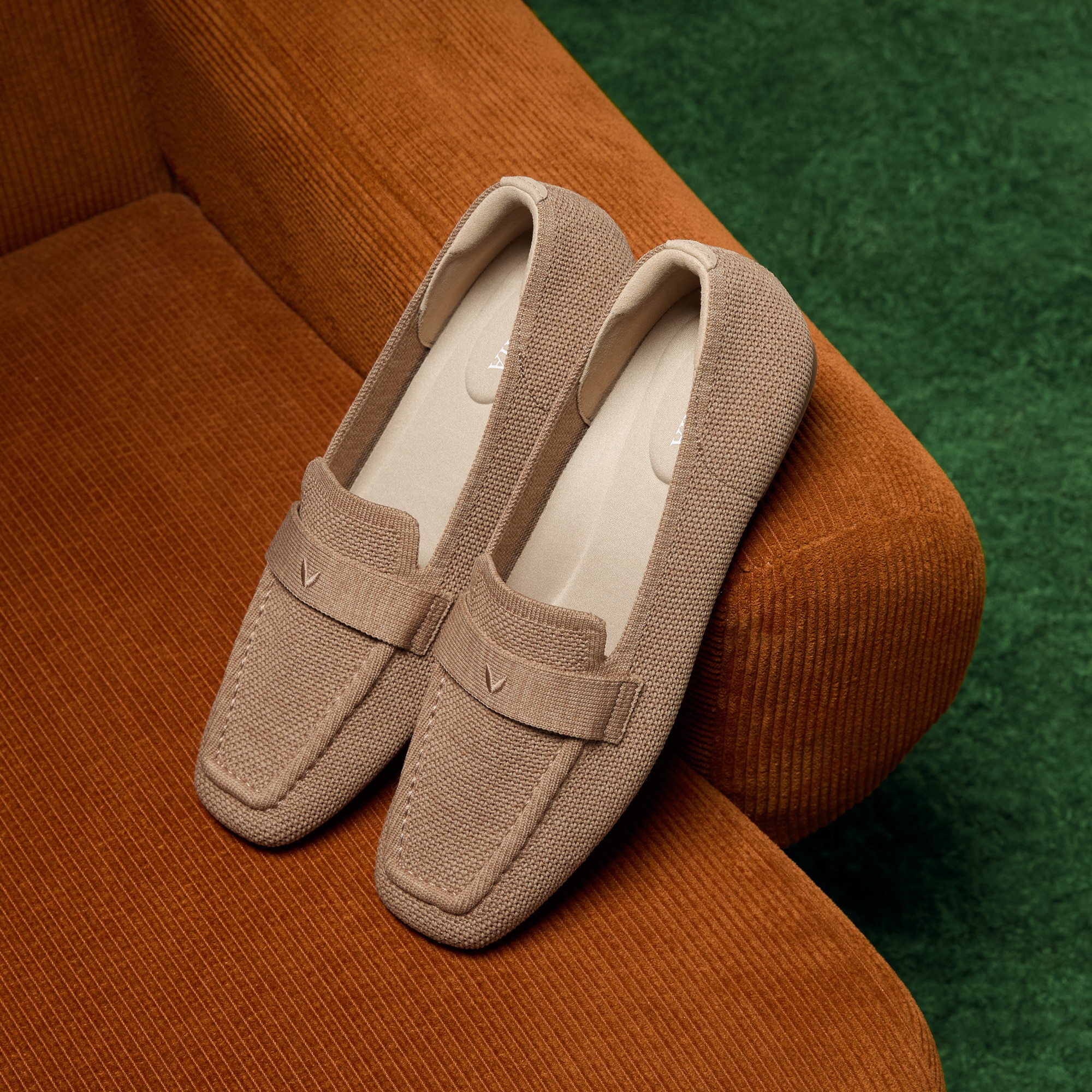 Silvie soft square-toe loafer in toffee brown resting on a corduroy sofa, showing the roomy knit upper