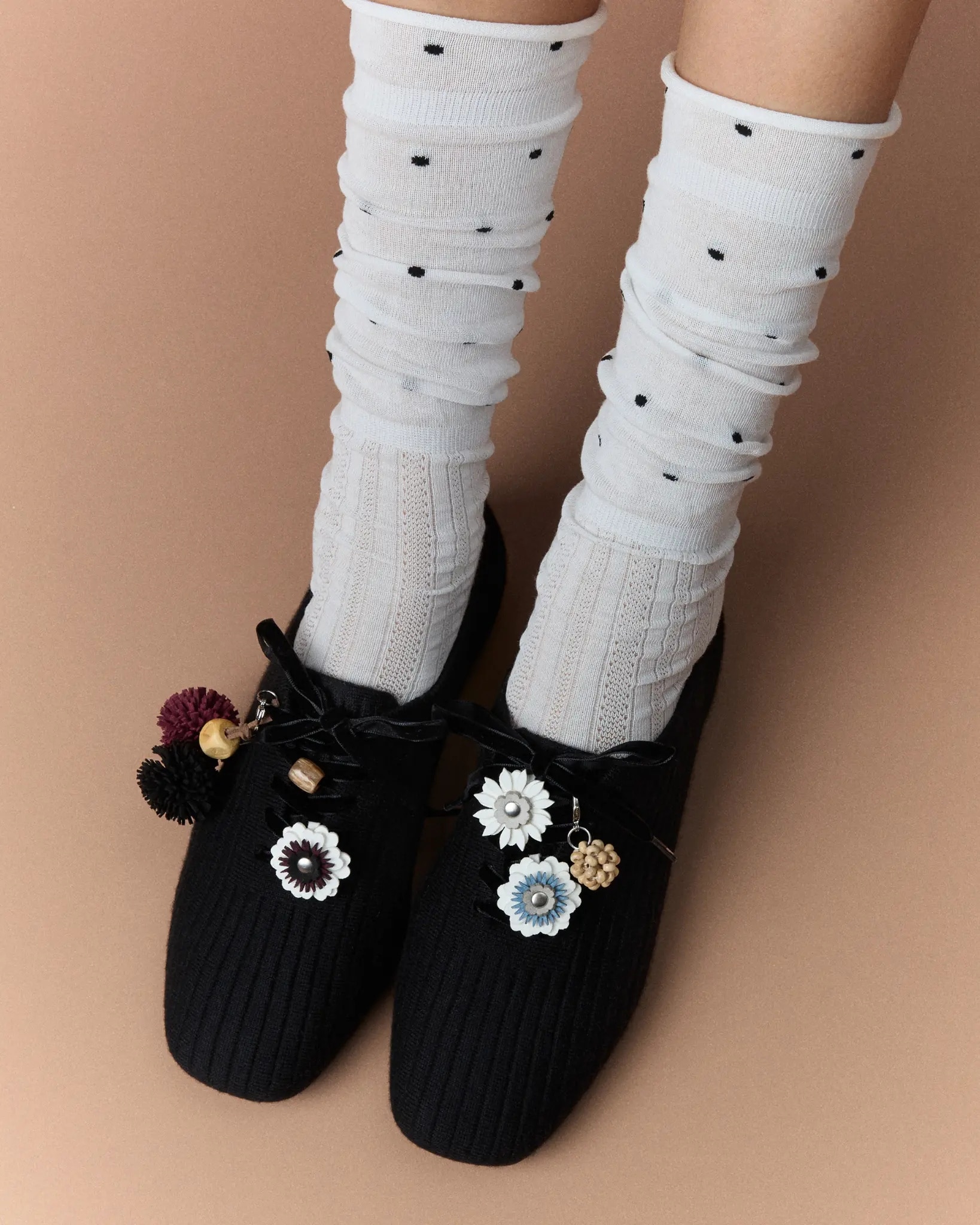 Model wearing black VIVAIA knit flats with white socks and flower charms