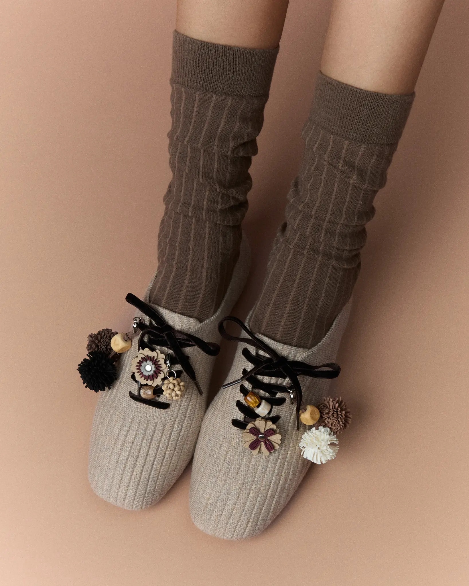 Model wearing taupe VIVAIA knit flats with brown socks and autumn charms