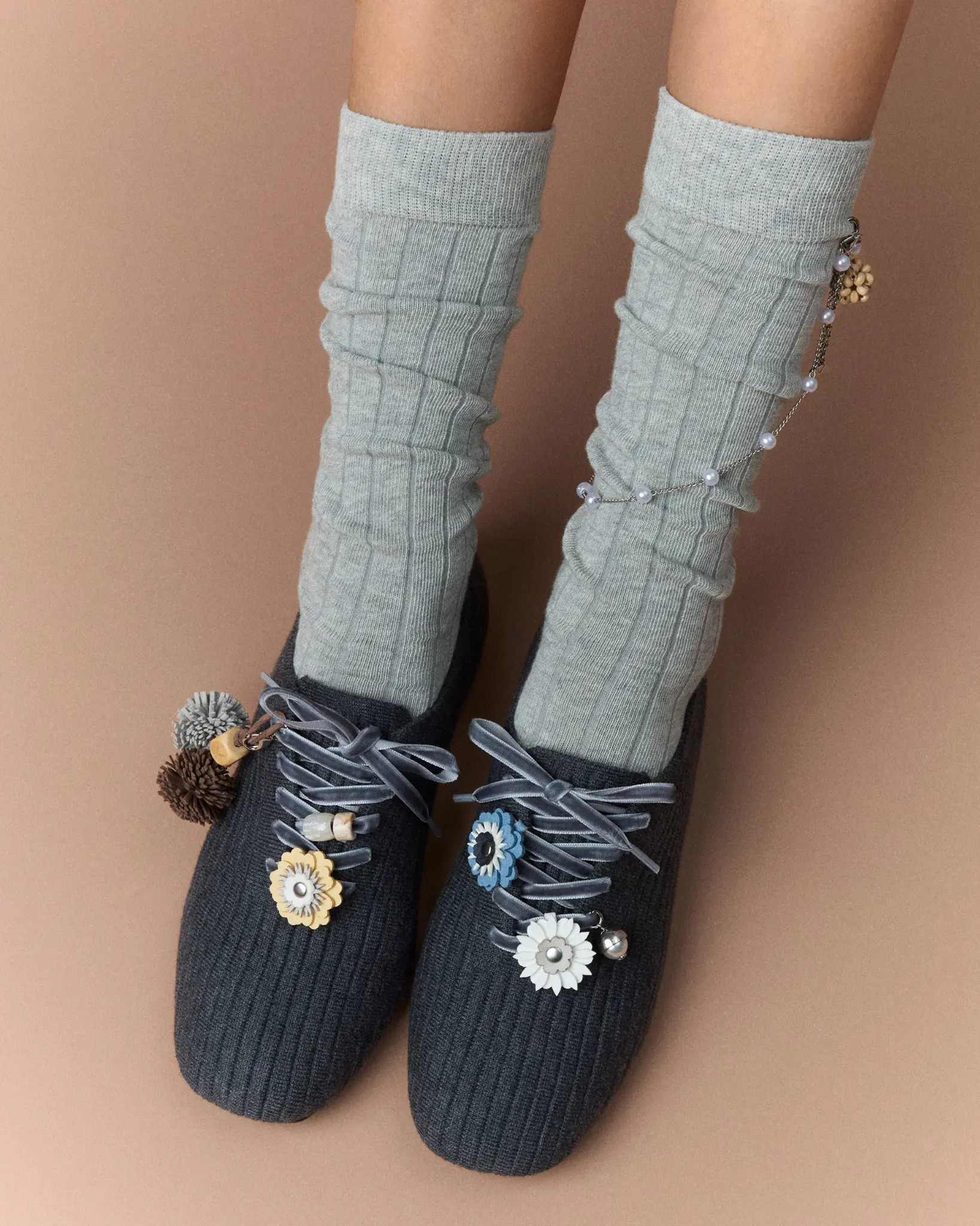 Model wearing navy VIVAIA knit flats with grey socks and flower charms