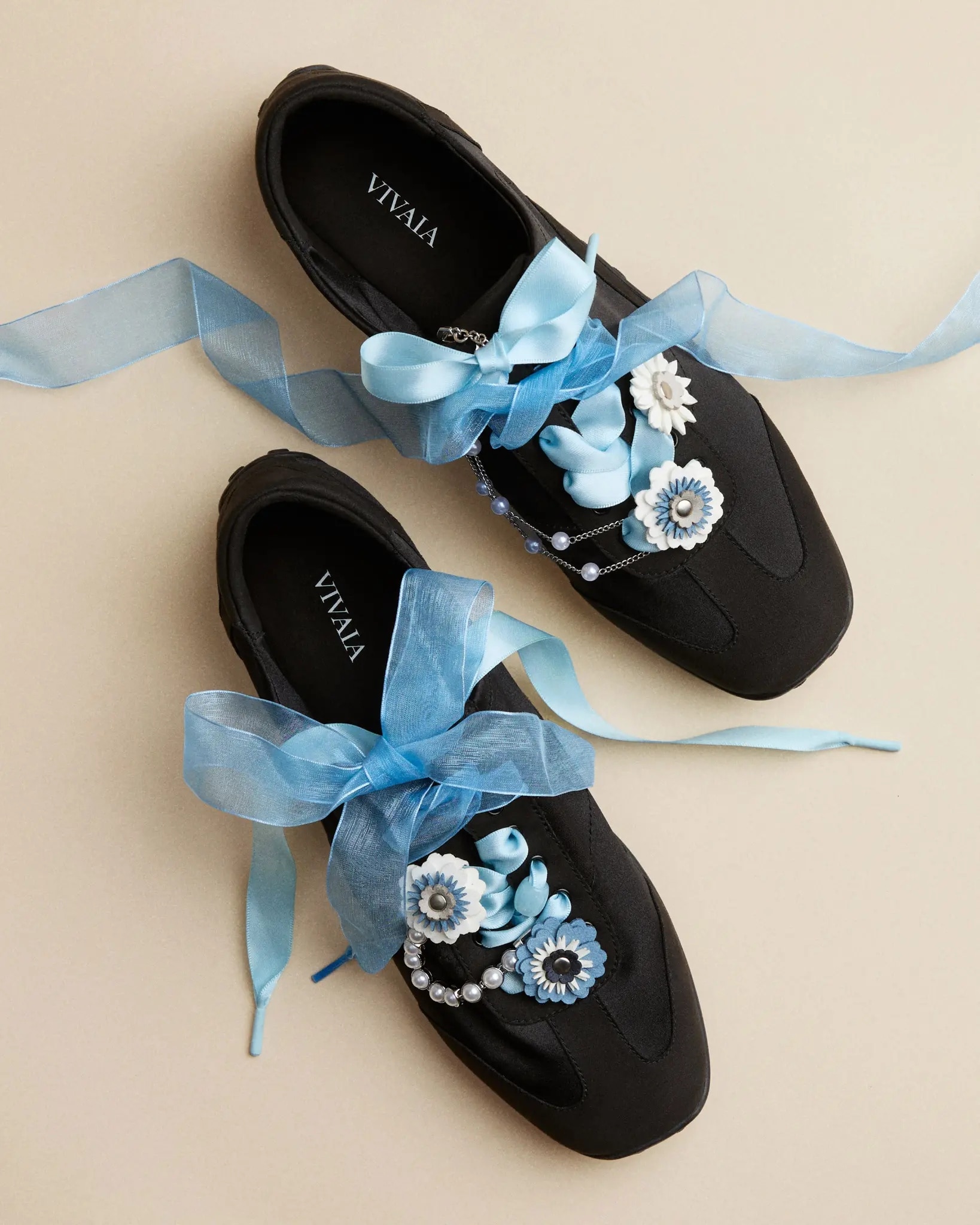 Black VIVAIA shoes styled with sky blue ribbons, blue and white flower charms, and pearl chains