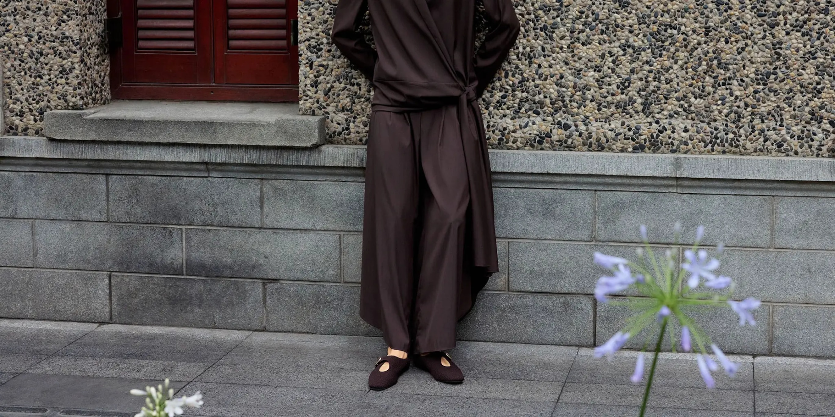 Woman wearing Jovin Mary Jane flats against a textured exterior wall